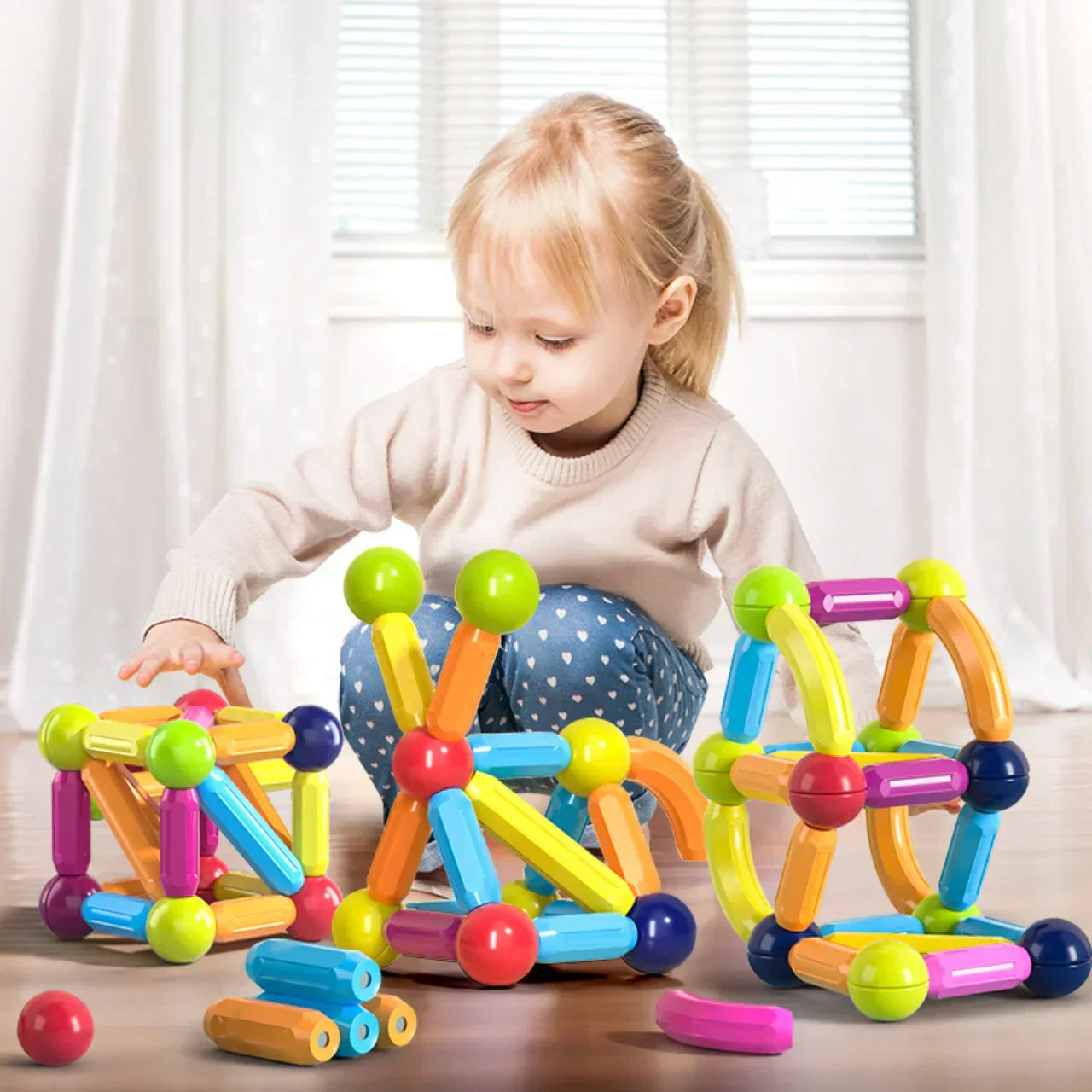Criança brincando e montando estruturas criativas com blocos magnéticos coloridos, estimulando habilidades motoras e imaginação.